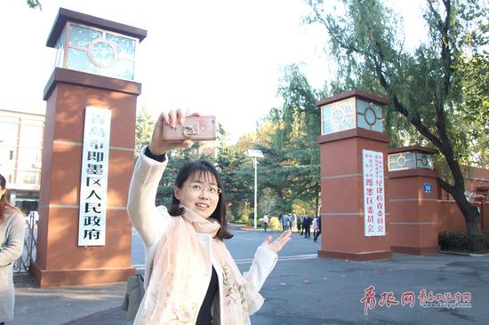 图为市民在青岛市即墨区人民政府门前拍照留念。