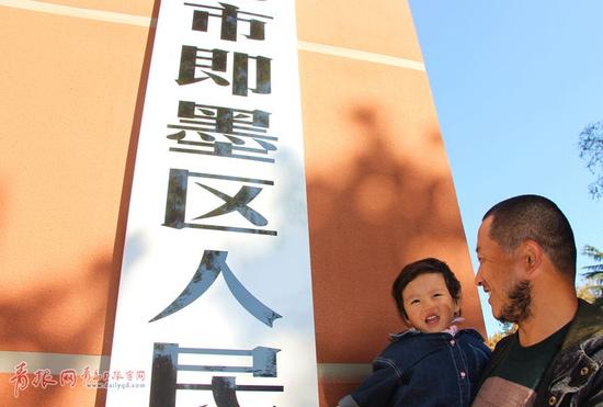 图为市民在青岛市即墨区人民政府门前拍照留念。