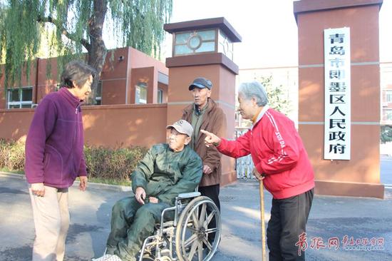 图为市民在青岛市即墨区人民政府门前。
