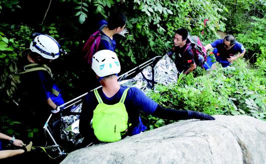救援人员抬着出事驴友艰难下山。(救援队供图)