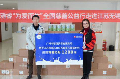 广州市蓓健贸易市场部经理谢昭强向无锡市儿童福利院院长陈国梅递交捐赠牌
