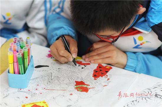 小学生练习为线板年画上色。(“青岛观”摄影师 王海滨)