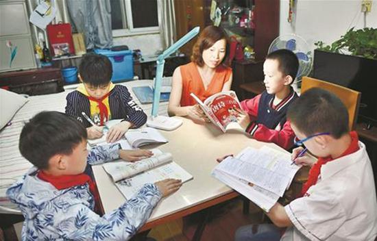 何晓云在家中为学生们辅导功课