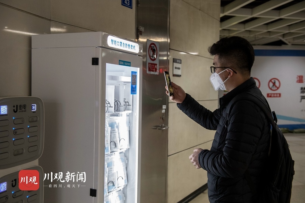 11月24日,一位乘客正在掃碼購買口罩