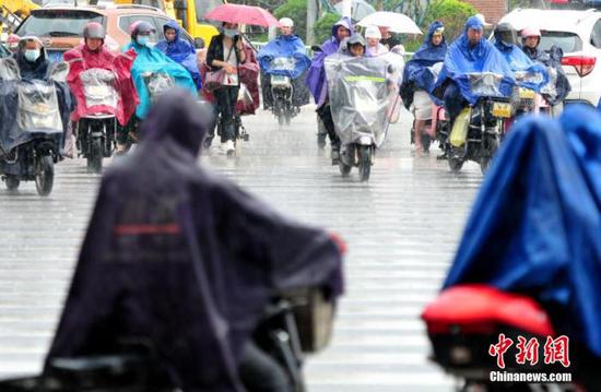 资料图为市民在雨中出行。张斌 摄