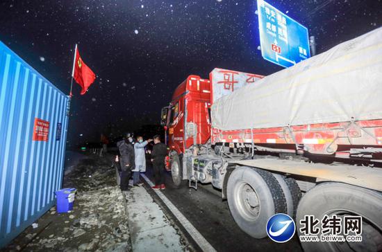 　2月8日，姜睿锟正在孟获城疫情防控卡点，为司机测量体温