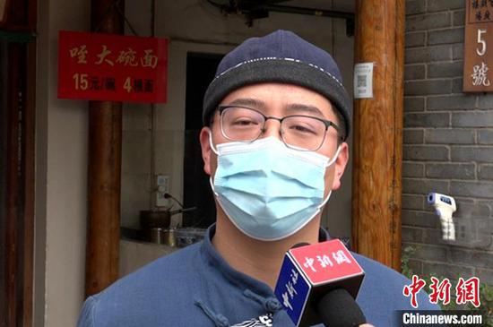 图为“咥大碗面”经营户陈建伟接受采访。 梅镱泷 摄