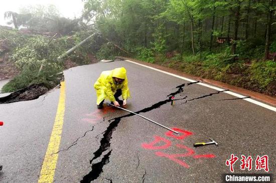地質(zhì)人員正在測量受損道路,劃定標點觀察裂縫變化情況。 趙飛 攝