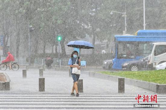 资料图：市民雨中出行。 中新社记者 陈骥旻 摄