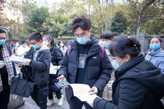 成都市七中育才水井坊校区考点门口，考生亮码亮证进入。