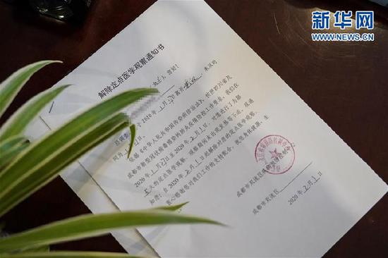 2月1日,一名結束醫(yī)學觀察的武漢滯留旅客得到成都市雙流區(qū)疾控中心發(fā)放的《解除定點醫(yī)學觀察通知書》作為健康證明。新華社記者 張超群 攝
