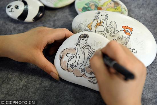 2020年6月12日,四川省南充市蓬安县嘉陵江石画工坊的画师在制作石画。CICPHOTO/刘永红 摄