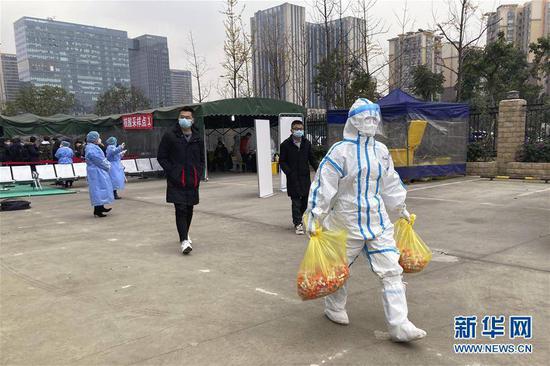 12月9日，在成都市第一人民医院，工作人员将核酸检测样本运出检测区域。新华社记者 沈伯韩 摄