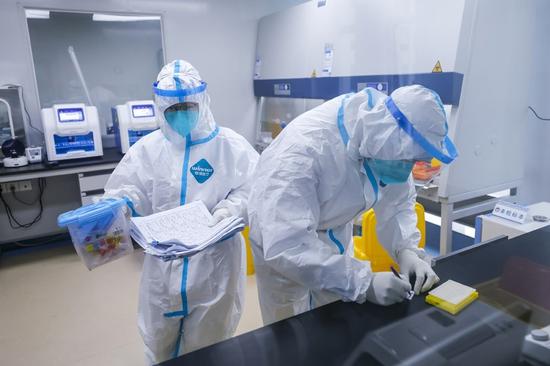 　12月10日，在郫都区中医医院核酸检测室，检测员准备处理核酸检测样本。新华社记者 沈伯韩 摄