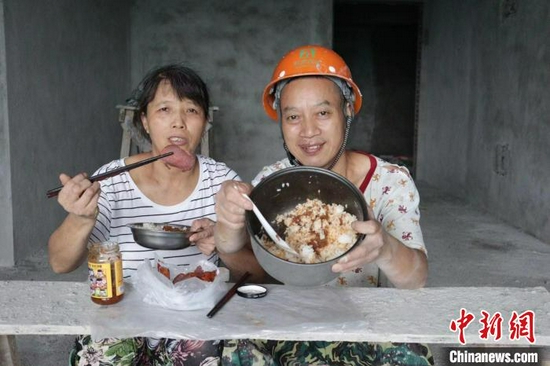 川哥和老婆在工地上吃饭. 受访者供图