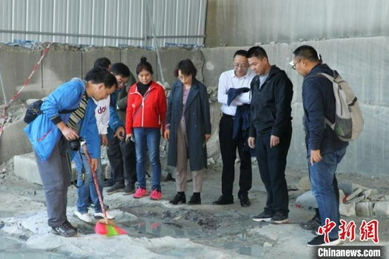 專家探究埋藏在砂巖中的恐龍化石。 隆昌市委宣傳部供圖