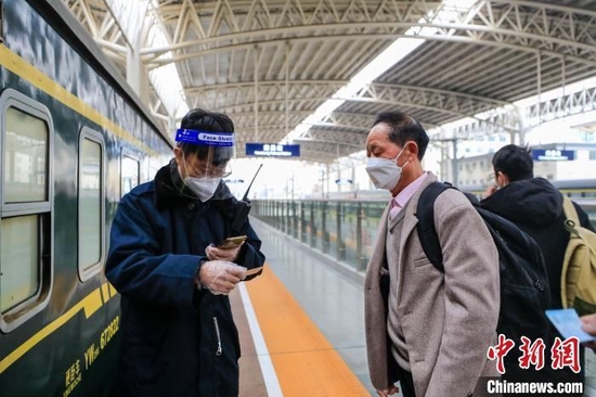 2023年春运期间，江西九江站列车工作人员查验车票。　高晋 摄