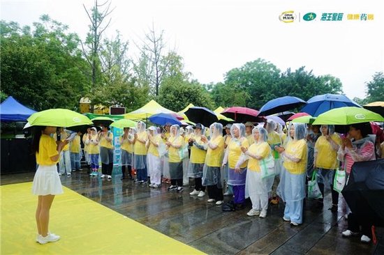 (市民在主持人带领下热身,为行走活动准备)