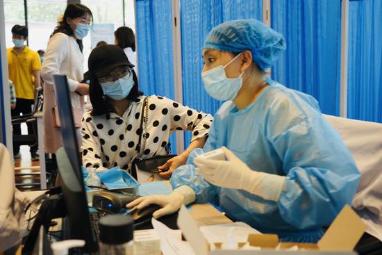 锦江区沙河街道新冠疫苗临时接种点,医护人员冯倩正在为居民接种。魏冯摄。