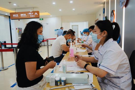 西华社区卫生服务中心内的预检区，工作人员正在询问居民相关问题。魏冯摄