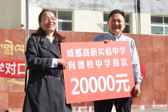 我校潘先根校长代表成都高新实验中学全体师生向德格县中学捐款两万元