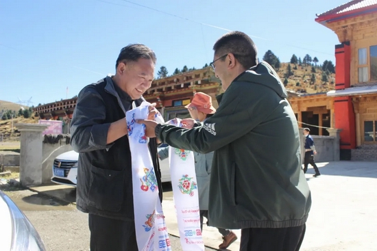 德格县委常委建康在错阿镇为潘校长献哈达