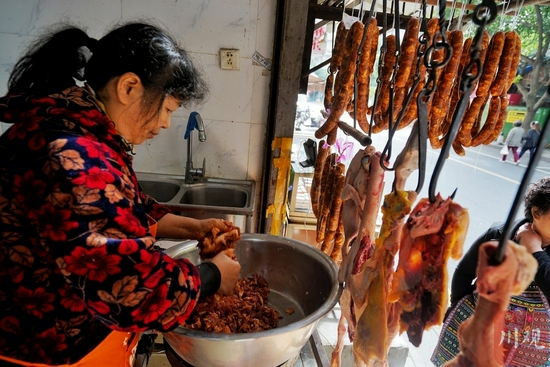 包家巷一肉铺老板正在为香肠调味