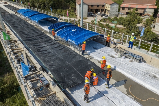 连日高温，施工人员给无砟轨道布设隔热降温遮阳棚。成兰铁路公司供图