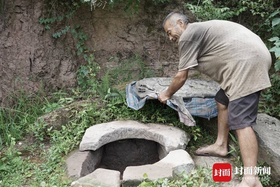 附的水井，栋大爹用坏雨伞和破布制作了一个简易“井盖”