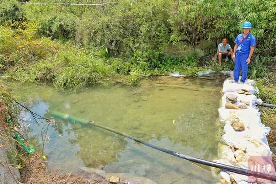 兩岔河提灌站,兩根黑色管道正在抽水。