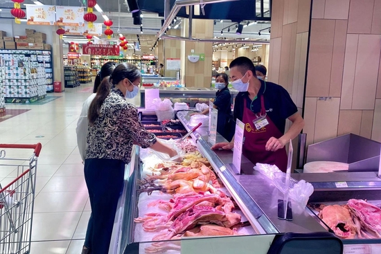 永辉超市广安加德天街店内市民在肉禽类柜台前挑选商品。 吴迪 摄