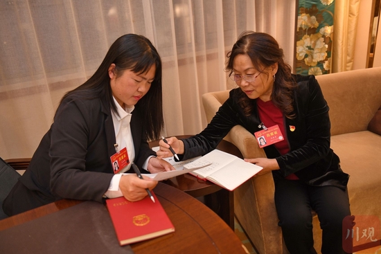2023年1月9日晚，省人大代表刘春香（右）在驻地与吴春梅代表进一步完善相关建议。