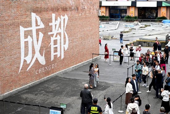 市民在东郊记忆红墙前合影留念