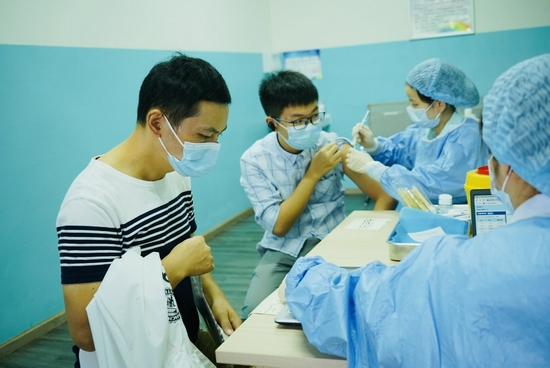 8月29日，万年场街道新冠疫苗接种点，医护人员正在为未成年人接种。魏冯摄。