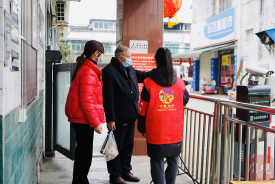 彭州市敖平鎮興平村金港灣小區,志愿者正在引導居民掃碼、測溫。魏馮 攝