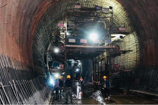 在江家口水库建设现场，全长1068米的导流洞内，近百名工人正进行隧洞混凝土浇筑作业。谭小龙 摄
