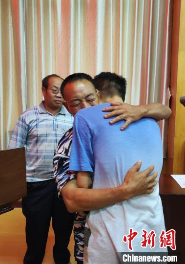 失踪26年的儿子腾海军与父亲紧紧相拥。　杨勇　摄