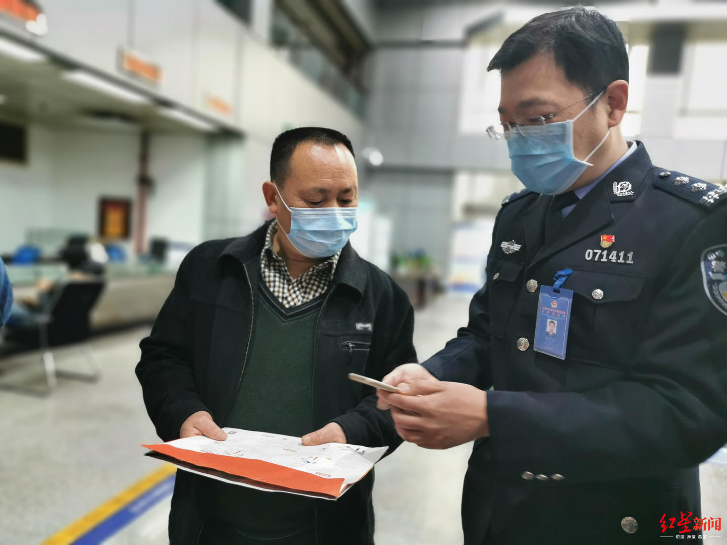 ↑民警向车主介绍申领机动车检验标志电子凭证