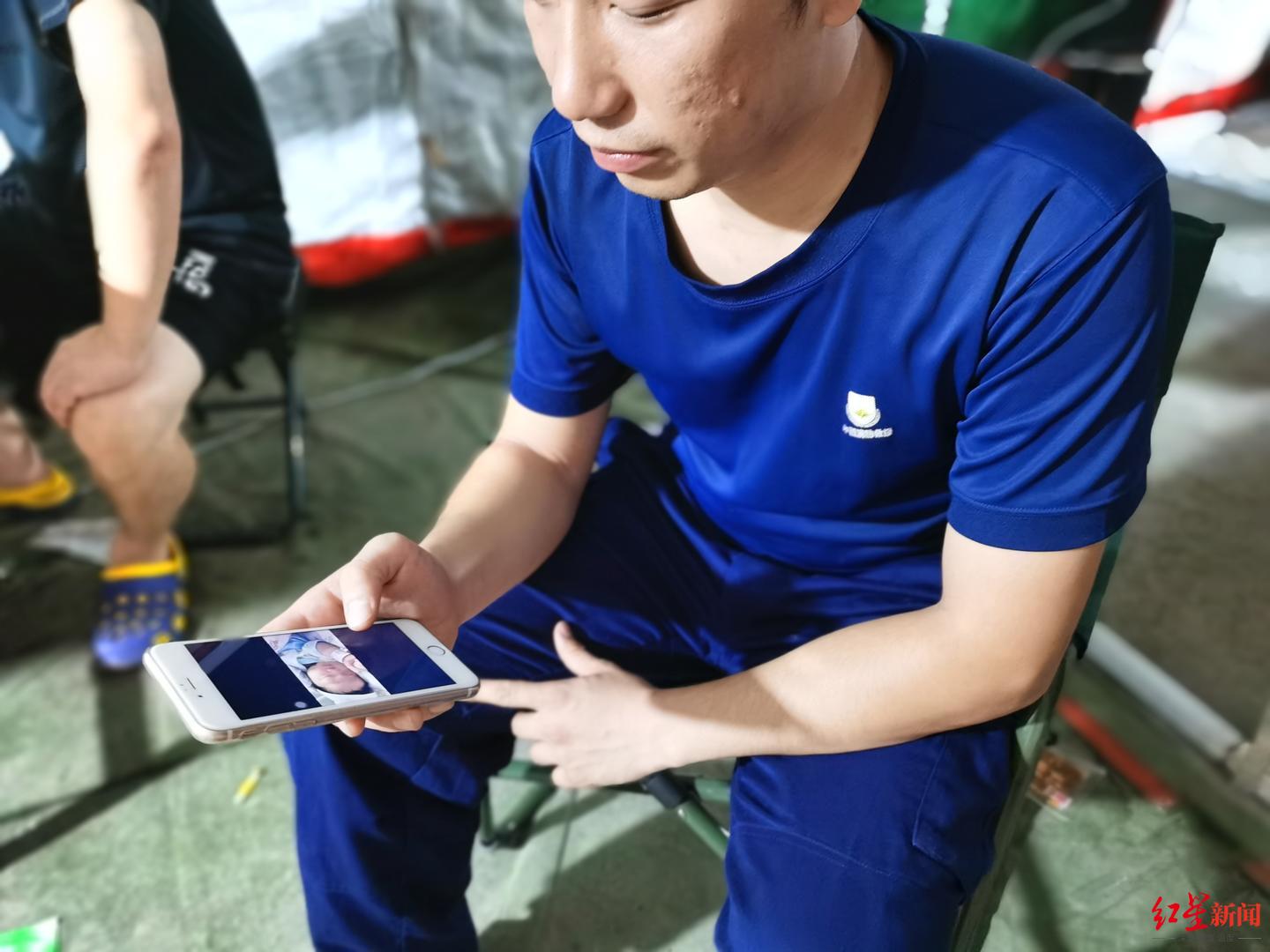 刘洪斌在看手机里女儿的照片