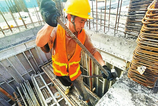 7月30日，位于成都市温江区的中建二局珠江新城国际项目工地，51岁的木工何新远正在高温下进行拆模工作。