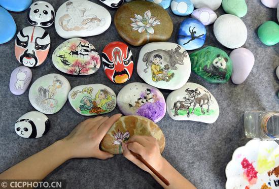 ↑2020年6月12日,四川省南充市蓬安县嘉陵江石画工坊的画师在制作石画。CICPHOTO/刘永红 摄