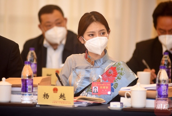 在四川省十四届人大一次会议小组会上，省人大代表杨越仔细聆听同组代表们的发言。