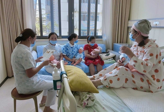四川绵阳，一家医院的医护人员向产妇宣传相关知识。资料图片（视觉四川 白桦 摄）