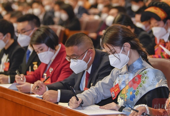 省人大代表杨越（右一）在大会上认真记录。
