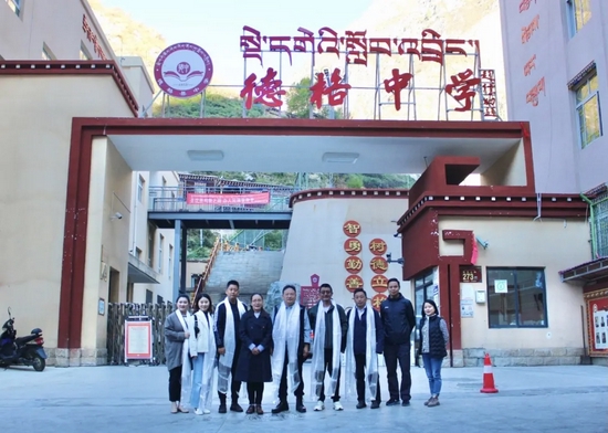 来校领导和老师在德格县中学门口合影