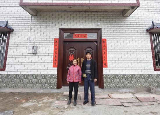 圖為1月20日,李光昭夫婦在新居門前留影。 新華社記者劉坤 攝