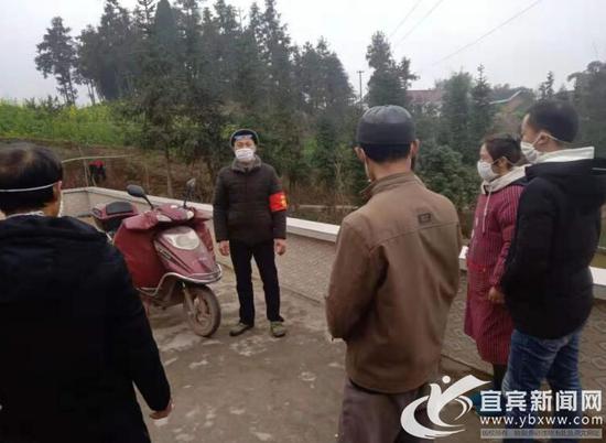 王志富(左二)到村民家中做宣传。(王健平 供图)