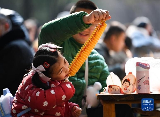 　　1月23日，在成都街头，游客在享用美食。新华社记者 王曦 摄