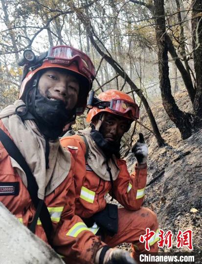 格绒翁修和队友居勉扑打完明火后准备下山时撤收水带时的照片。　甘孜森林消防 摄