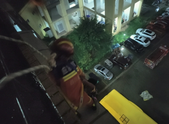 消防救援人员从楼顶垂直下降到雨棚展开救援 高颖摄